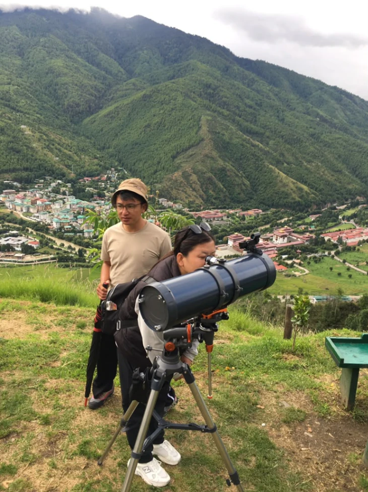 Guide explaining the night sky and telescope alignment to visitors