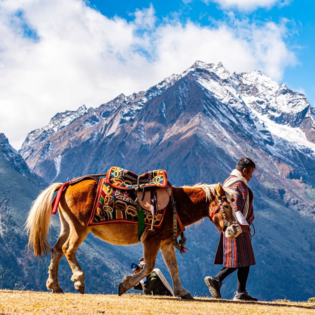 A small group of travelers walking a scenic mountain trail in Bhutan